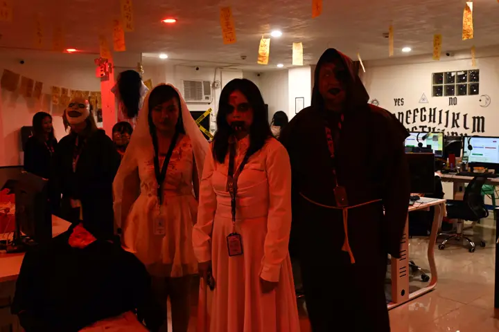Brides and a hooded monk walking through the office