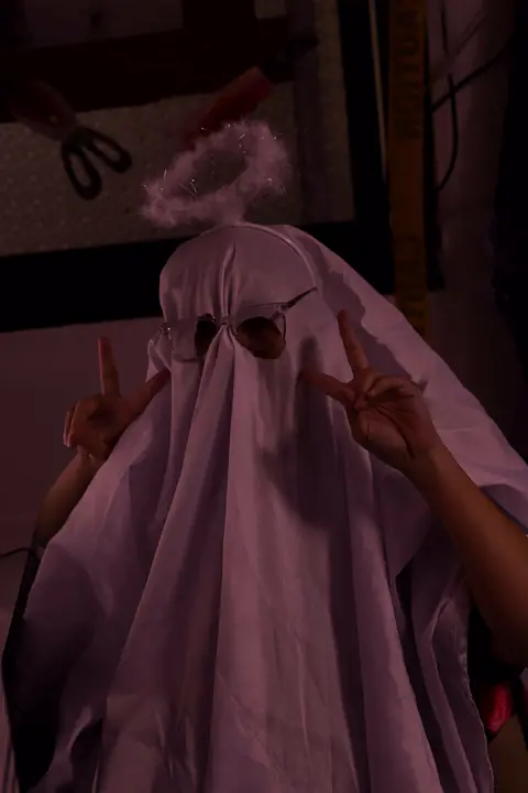 Agent dressed as a sheet ghost at the office